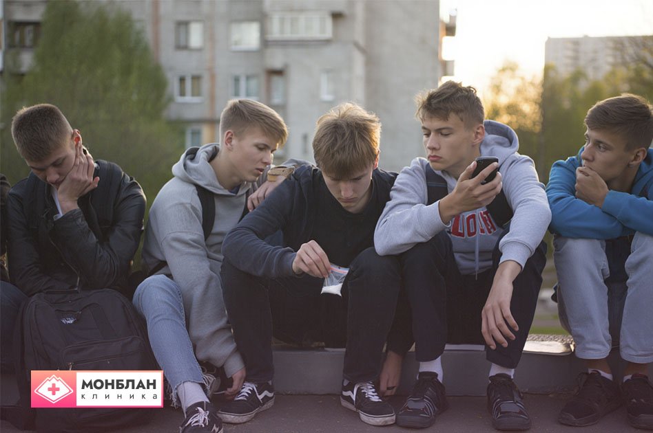 Группа подростков рассматривает пакетик порошка